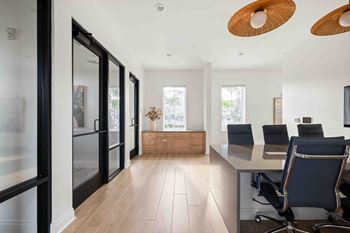A modern office with a glass wall and a wooden floor