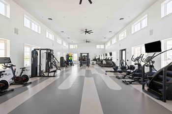 A spacious gym with a variety of exercise equipment and a person working out