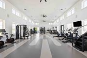 Vero Beach apartment for rent - A spacious gym with a variety of exercise equipment and a person working out at Verity Luxury Apartments, Florida