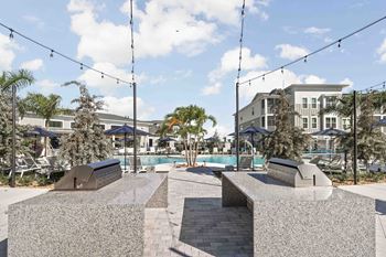 A park with a bench and a pool in the background