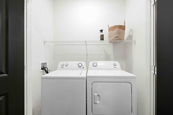 A white washing machine and dryer in a small laundry room