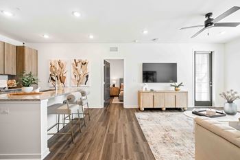 A modern living room with a kitchen area in the background