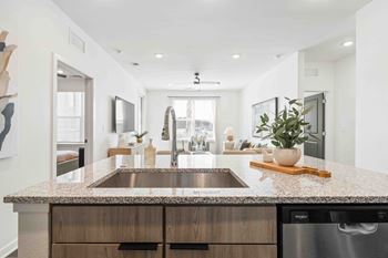 A modern kitchen with a granite countertop and stainless steel appliances