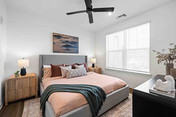 A bedroom with a large bed and a ceiling fan