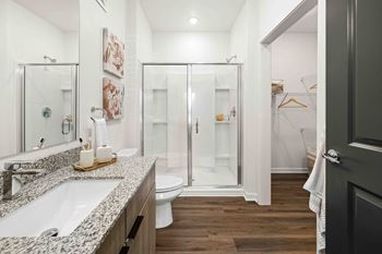 A bathroom with a white sink and a walk-in shower