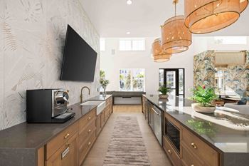 A modern kitchen with a black television mounted on the wall