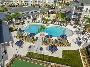An aerial view of a resort with a pool and palm trees