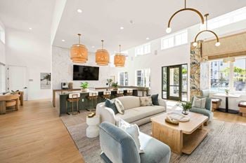A modern living room with a bar area and a kitchen in the background