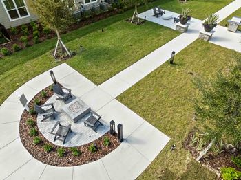 A circular patio with a fire pit and chairs