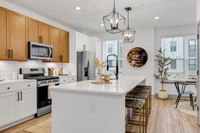 Woodbury townhouse for rent - an open kitchen with a large white island with a counter top at Meridian at CityPlace, Woodbury