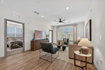 Phoenix apartment for rent - A living room with a green chair and a lamp on a side table.