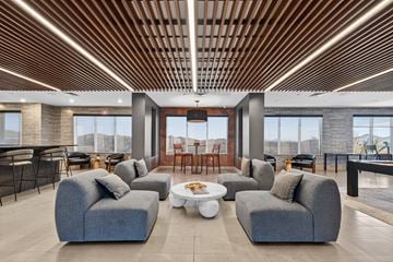 Phoenix apartment for rent - A modern living room with grey couches and a wooden ceiling.