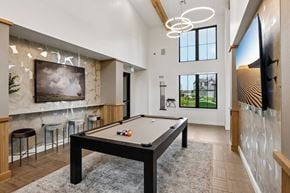 Longmont apartment for rent - A pool table is in the middle of a room with a bar and a television.