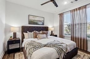 Longmont apartment for rent - A bedroom with a large bed and a ceiling fan.