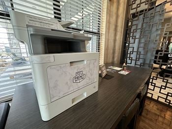 A printer in a hotel room in front of a window