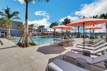A swimming pool with chaise lounge chairs and umbrellas