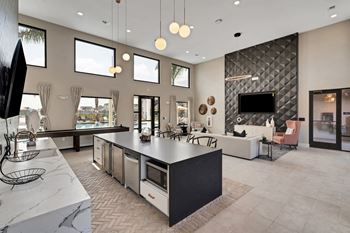 A kitchen with a large center island next to a living room with a couch and a tv