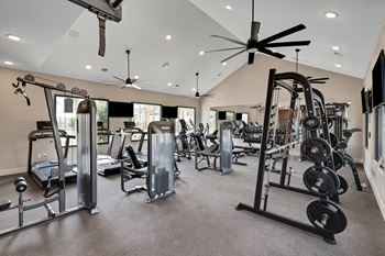 A spacious fitness center with cardio equipment and a large window