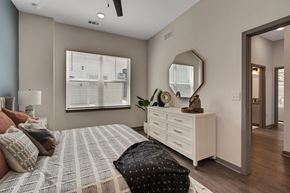 North Venice triplex for rent - a bedroom with a large bed and a dresser with a mirror  at The Sophia, Venice, FL, 34275