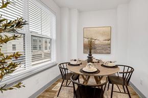Woodbury townhouse for rent - a dining room with a table and chairs and a large window at Meridian at CityPlace, Woodbury, MN 55125