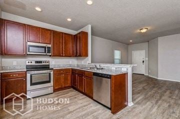 Converse house for rent - A kitchen with wooden cabinets and stainless steel appliances is on the market with Hudson Homes.
