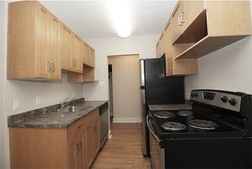 Winnipeg apartment for rent - a kitchen with black appliances and wooden cabinets