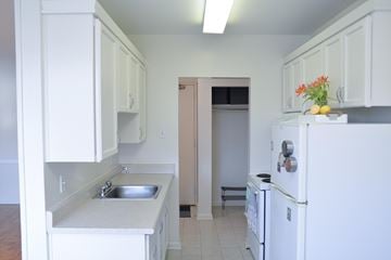 Winnipeg apartment for rent - A kitchen with white cabinets and a white fridge.