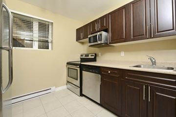 Winnipeg apartment for rent - A kitchen with brown cabinets and white appliances.