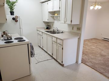 Winnipeg apartment for rent - A kitchen with white cabinets and a white refrigerator.