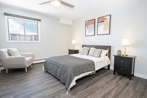 Winnipeg apartment for rent - a bedroom with a bed and a chair and a window