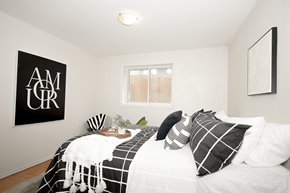 Winnipeg apartment for rent - A bedroom with a bed, pillows, and a poster on the wall.