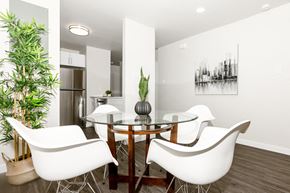 Winnipeg townhouse for rent - A modern dining room with a glass table and white chairs.