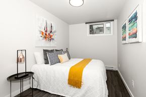 Winnipeg townhouse for rent - A bedroom with a white bed and a yellow throw.