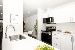 Winnipeg townhouse for rent - A modern kitchen with white cabinets and a stainless steel sink.
