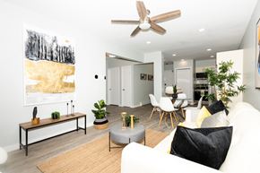 Winnipeg apartment for rent - A living room with a white couch, a rug, a coffee table, and a painting on the wall.