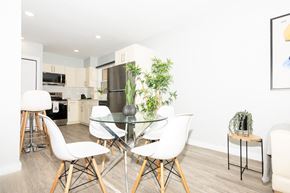 Winnipeg apartment for rent - A modern kitchen with a glass table and white chairs.