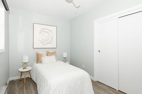 Winnipeg apartment for rent - A bedroom with a white bed and a framed artwork on the wall.