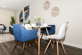 Winnipeg townhouse for rent - A dining room with a blue chair and white chairs.