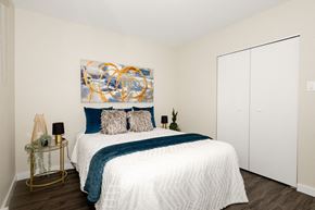 Winnipeg townhouse for rent - A bedroom with a large bed and a painting on the wall.