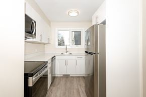 Winnipeg townhouse for rent - A kitchen with white cabinets and a refrigerator.