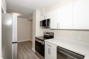 Winnipeg townhouse for rent - A kitchen with a refrigerator, microwave, oven, and dishwasher.