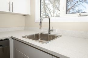 Winnipeg townhouse for rent - A kitchen sink with a faucet and a window in the background.