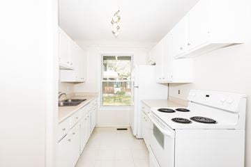 Winnipeg apartment for rent - A white kitchen with a stove and sink.