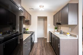 Winnipeg apartment for rent - A kitchen with dark wood cabinets and a white countertop.