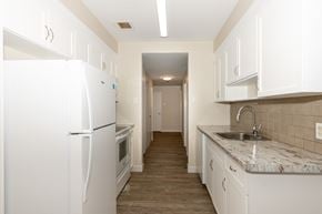 Winnipeg apartment for rent - A kitchen with white appliances and cabinets.