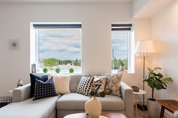 Winnipeg apartment for rent - A living room with a grey couch and a large window.