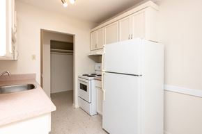 Winnipeg apartment for rent - A white refrigerator is in a kitchen with a sink and stove.