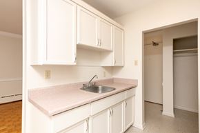 Winnipeg apartment for rent - A kitchen with white cabinets and a pink countertop.