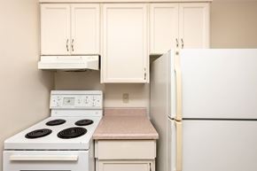 Winnipeg apartment for rent - A kitchen with a white stove and a white refrigerator.