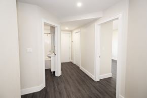 Winnipeg triplex for rent - a hallway with white walls and hardwood floors